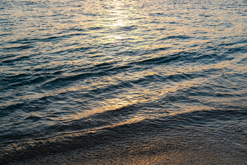 sea ​​water with the glow of the setting sun, the color of the sea at sunset, sunset sea water, sunset on the beach, sunset over the sea, waves on the beach, small waves of the sea, orange sea water