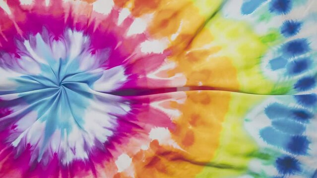Animated swirl tie dye colourful background waving. Liquid holographic background. Smooth silk cloth surface with ripples and folds in tissue. 4K seamless looping animation.