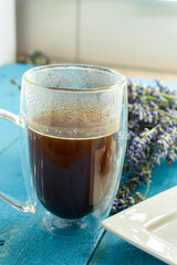 Cup of coffee on a blue background. Composition with lavender and coffee with strudel