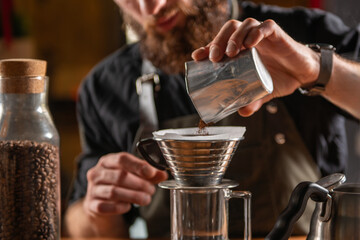 Skilled barista using the Kalita Wave dripper coffee maker to create a meticulously brewed cup of coffee