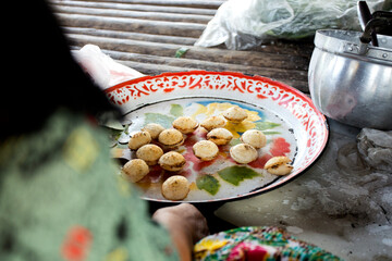 Woman preparing coconut thai desserts. Kanom krok is a tasty Thai coconut milk based mini pancakes popular street food as well. - obrazy, fototapety, plakaty