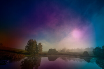 an autumnal landscape with pond and fog