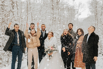 A group of young people, friends of the bride and groom, throw snowballs together with the bride...