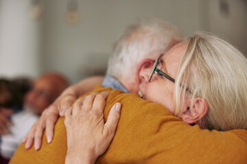 Senior friends hugging during a visit