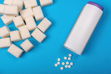 sugar cubes on a blue background and sweetener tablets