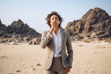 Fototapeta premium Lifestyle portrait photography of a tender mature woman blowing kisses wearing a professional suit jacket at the socotra island in yemen. With generative AI technology