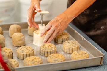 Mooncake making process. A mooncake  is a Chinese bakery product traditionally eaten during the Mid-Autumn Festival.
