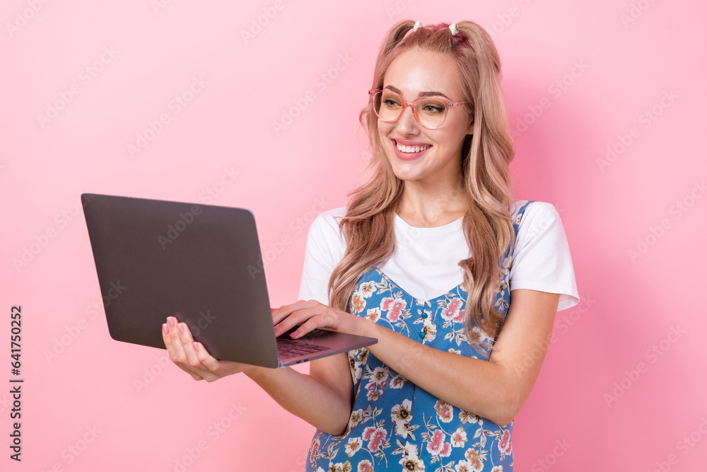 Poster Photo of pretty positive girl toothy smile use wireless netbook chatting social network isolated on pink color background