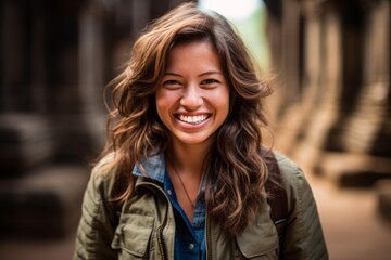 Naklejka premium Lifestyle portrait photography of a grinning girl in her 30s wearing a rugged denim jacket at the angkor wat in siem reap cambodia. With generative AI technology
