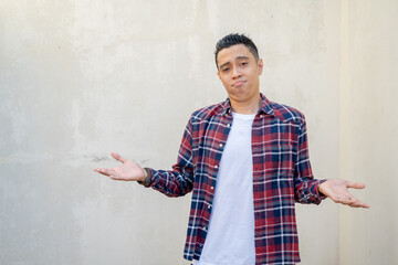 Indonesian man wear casual clothes with why gesture. The photo is suitable to use for man...