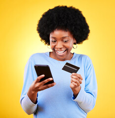 Happy black woman, phone and credit card in online shopping against a yellow studio background. Excited African female person with afro smile on mobile smartphone app in ecommerce, payment or banking