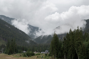 View of ski village Jasna in Low Tatras (Nízke Tatry, Demänovská Dolina) National Park in central Slovakia. Low clouds in front of a mountain ridge.