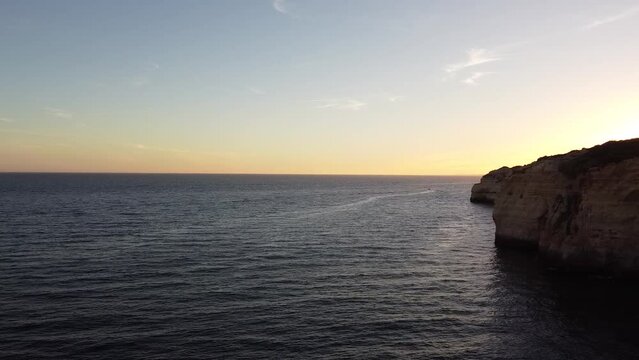 Sea Shoreline with Beautiful Sunset and Calm Water. Left pan aerial drone view.