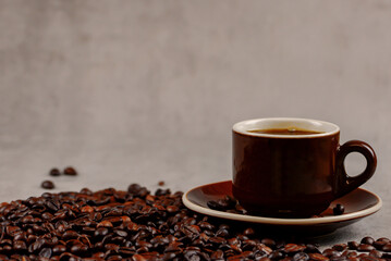 Coffee beans and coffee in a cup on a gray background