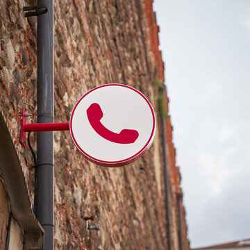 Hinweis auf ein öffenliches Telefon durch ein Schild in der Altstadt von Verona in Italien
