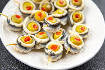 olive stuffed anchovy fillets, anchovy roll stuffed olives apetizing seafood pickled fish marinated ready to eat appetizer meal food snack on the table copy space food background rustic top