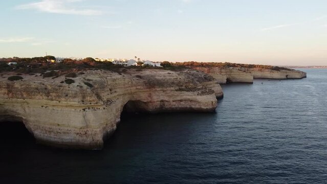 Left Long Slow Pan Aerial View of Cliffs and Ocean. Landscape 4k view from above. Showing rocky shoreline and the sea.