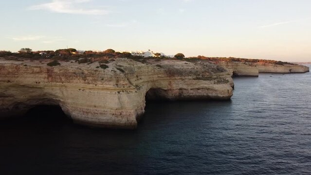 Aerial Pan of Ocean Shore of Caves and Rocks. Pan right of seashore.