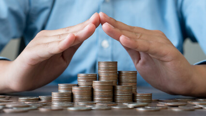 Stacked coins is protected by human hand.Risk management.Assets wealth, money saving or money...