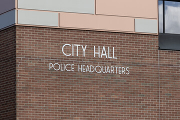City Hall and Police Headquarters in bold stainless steel text on brick. City Hall is the administration building of a municipal government.