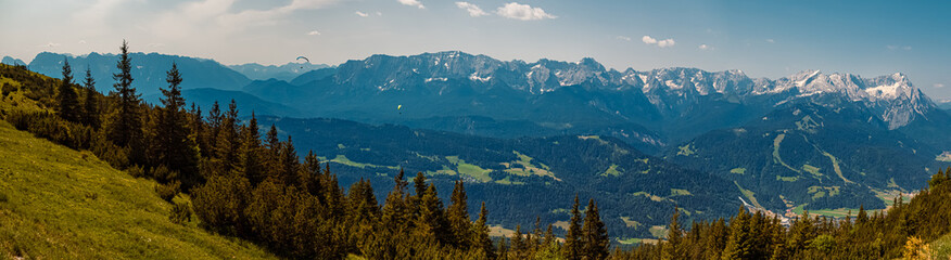 Fototapeta premium High resolution stitched alpine summer panorama with a paraglider at Mount Wank, Garmisch-Partenkirchen, Bavaria, Germany