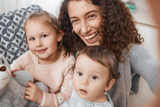 Selfie, smile and portrait of mother with her children bonding, relaxing and playing in the living room. Happy, love and young mom taking a picture with her kids for memory together in lounge at home