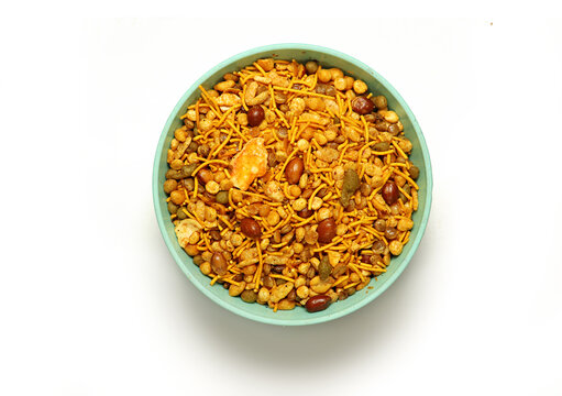 Indian Namkeen Snacks served in ceramic bowl Indian traditional Namkeen on a white background, Food Mixture,Navratna Mix Namkeen Also Know as Nimco, Namkin, Mixture,chiwda, Nimko ( Top View)