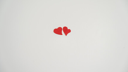Paper heart and wedding rings on a white background.