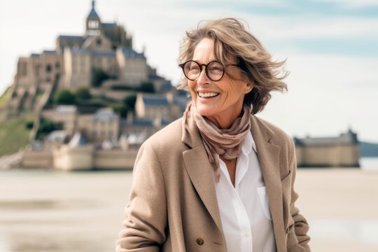 Lifestyle portrait photography of a joyful mature woman wearing a stylish blazer at the mont saint-michel in normandy france. With generative AI technology