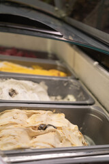 Traditional Italian artisan ice cream gelato at showcase in the fridge