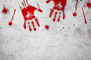 Bloody handprints, stain and splatter on the concrete wall.