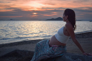 Fototapeta na wymiar Pregnant woman enjoying a beautiful sunset
