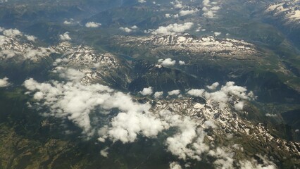 Aerial View of the Alps Covered in Snow and Clouds Seen From Airplane