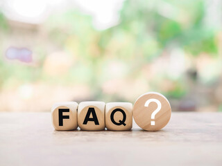 Wooden block with word the FAQ with question marks. The concept of question or answer time.