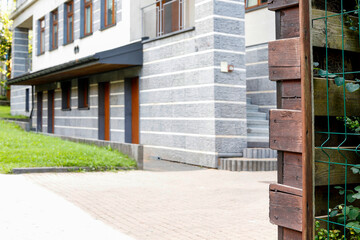 A view from behind a wooden fence to a modern building. Shot as if a spy was watching.