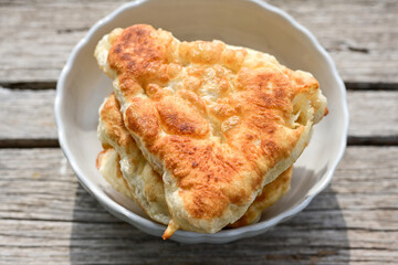 Traditional Bulgarian home made deep fried  patties  covered with sugar  оn rustic backgroud.Mekitsa or Mekica,  on wooden  rustic  background. Made of kneaded dough that is deep fried 