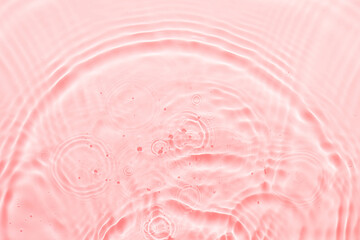 Water pink surface abstract background. Waves and ripples texture of cosmetic aqua moisturizer with bubbles.