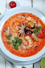  Tom yam on a white wooden background in an iron bowl