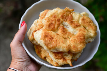 Traditional Bulgarian home made deep fried  patties  covered with sugar  оn rustic backgroud.Mekitsa or Mekica,  on wooden  rustic  background. Made of kneaded dough that is deep fried 