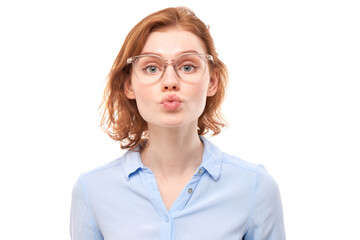 Portrait of young beautiful woman with red hair sending air kisses isolated on white studio background.