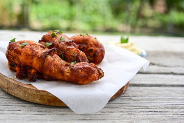 Crispy  deep fried home made    chicken   legs  Breaded  with  almond flour chicken  breast fillets  with chilly peppers and fresh   basil on wooden rustic background. Ketogenic diet food