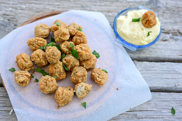 Crispy  deep fried   chicken  nuggets . Breaded  with Cornflakes Breast fillets  with chilly peppers and fresh   basil on wooden rustic background