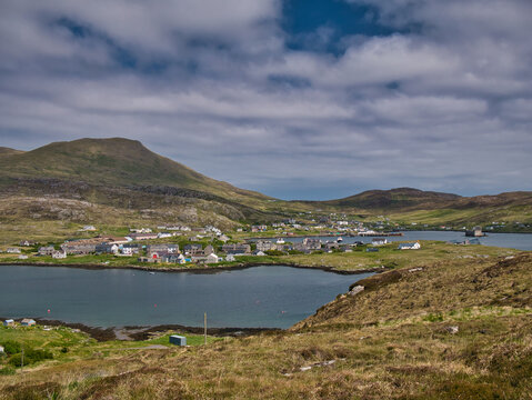 The village of Castlebay on the island of Barra in the Outer Hebrides, Scotland, UK. Taken looking northeast with the hill of Heaval, the highest point on Barra in the background.