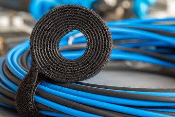 Roll of hook and loop, velcro tape with bundle of cables, electrical installations accessories and telecommunication