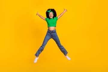 Fototapeta na wymiar Full body portrait of active overjoyed person jumping raise hands make star figure isolated on yellow color background