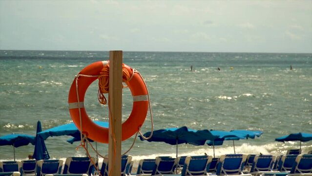Slow motion, closeup lifeguard float with the beach in the background, on a sunny day.