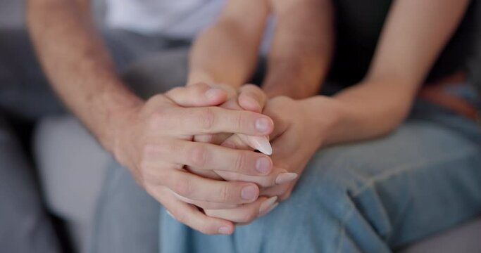 Couple, love and holding hands in home for care, help and support of empathy, gratitude or sorry. Closeup of man, woman and hand of partner for loyalty, healing and trust of kindness, hope or forgive