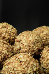 Healthy energy balls with sesame and sunflower seeds on dark background