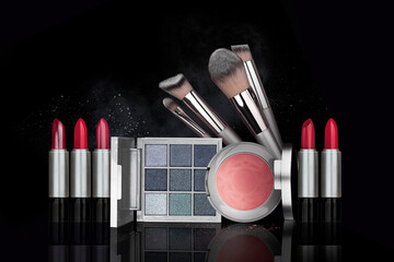 Eye shadow, blush brushes, purple, pink, red powder dust on black background. Highly vibrant...