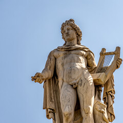 Obraz premium Apollo marble statue, the ancient Greek god of Fine Arts isolated on a plain sky background. Travel to Athens, Greece.